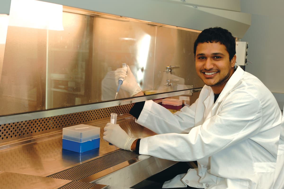 Student smiling while working in a lab